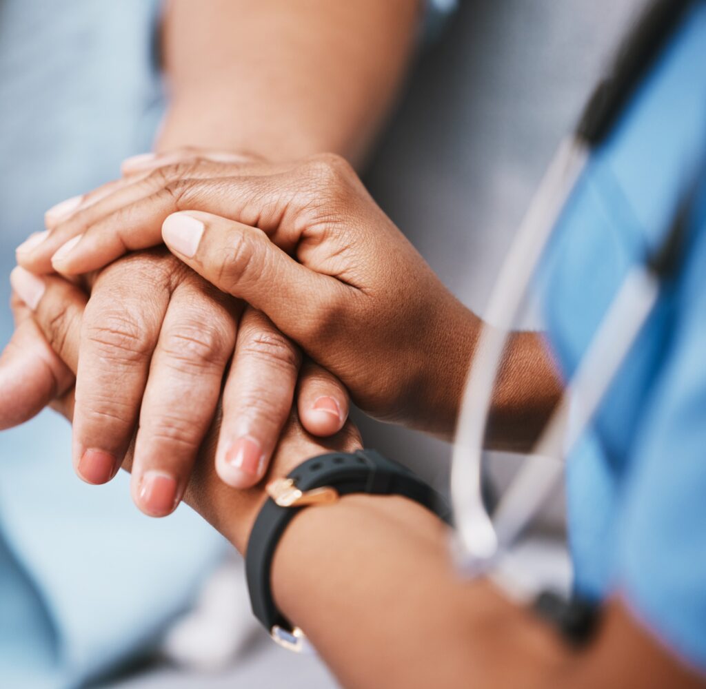 A patient's hand is held at the Oncology and Hematology Clinic at Eaton Rapids Medical Center